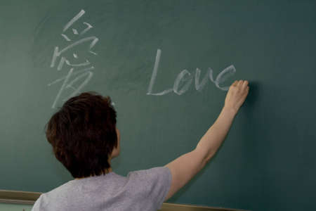 Female teacher writing on a blackboard の写真素材