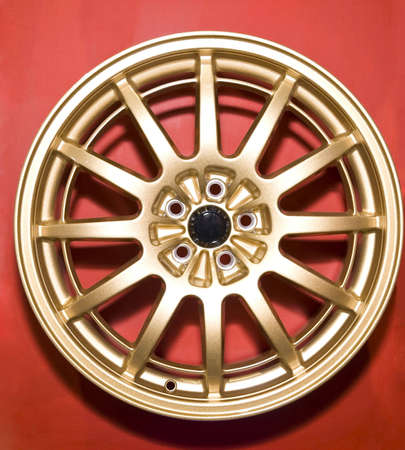 a golden hubcap isolated over red background の写真素材