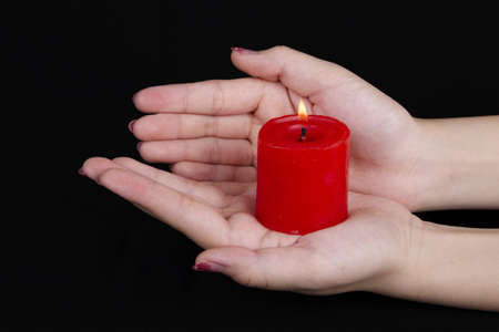 hands keeps burninging candle in the dark の写真素材