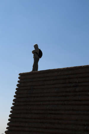 young man on the top of the building with blue sky backgroundの写真素材