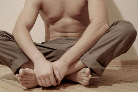 man body sportsman sit floor hands legsの写真素材