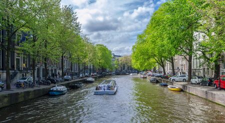 Beautiful Amsterdam Canals with boats docked alongside houses Netherlandsの写真素材