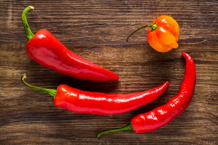 Assortment of peppers on a textured dark wood background