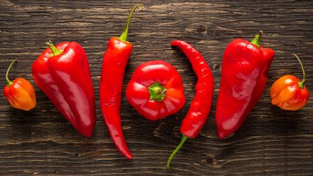 Assortment of fresh peppers on a textured dark wood backgroundのeditorial素材