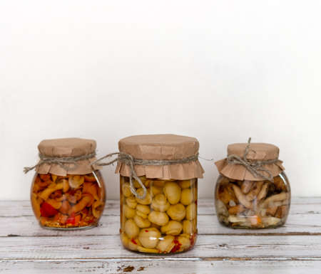 homemade pickled mushrooms in a glass jar on White background. Canned mushrooms close up, copy space;の写真素材