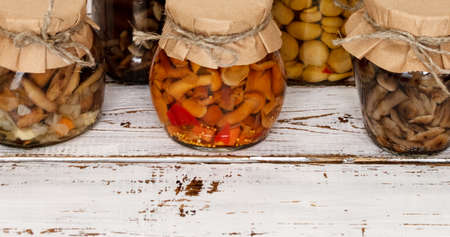 homemade pickled mushrooms in a glass jar on White background. Canned mushrooms close up, copy space;の写真素材