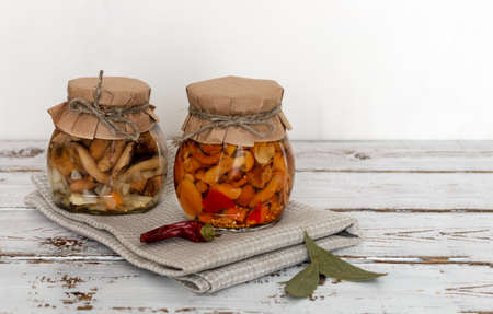 homemade pickled mushrooms in a glass jar on White background. Canned mushrooms close up, copy spaceの写真素材
