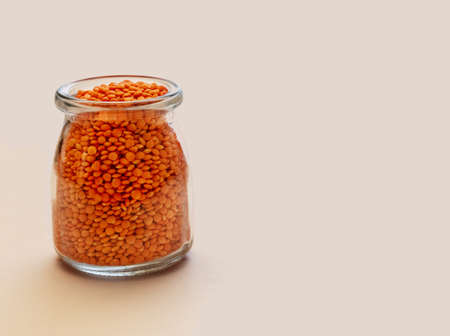 Glass jar with lentils on a light background. Nutritious and important source of proteinの写真素材