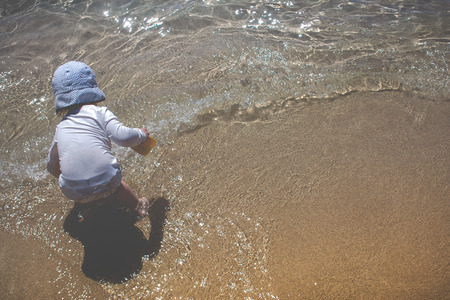 Toddler Child Plays At The Shore On A Tropical Beach Vacationの写真素材