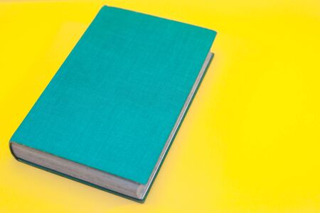 Turquoise Vintage Book WIth Vibrant Yellow Backgroundの写真素材