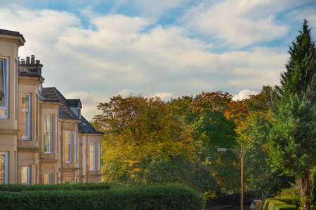 Blonde Sandstone Terrace Houses and Autumn Leaves on Trees on a Residential Street in the Southside of Glasgow Scotlandの写真素材