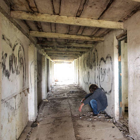 alcoholic sitting at the wallの写真素材