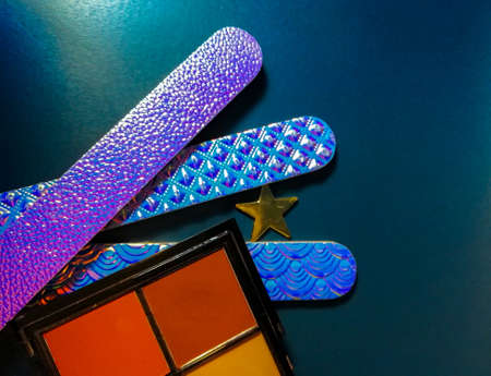 cosmetics eye shadow and nail files on a blue backgroundの写真素材