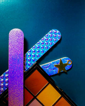 cosmetics eye shadow and nail files on a blue backgroundの写真素材