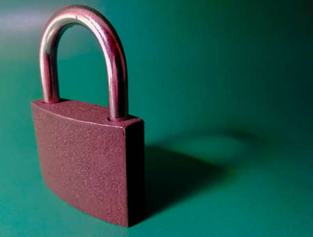gray iron door lock on a green backgroundの写真素材