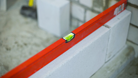 checking evenness of aerated concrete wall with bubble level