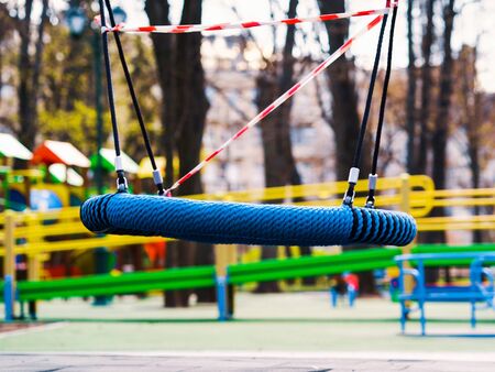 Lonesome swings on abandoned playground during covid pandemicの写真素材