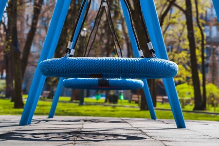 Blue swings on empty playground during COVID-19 pandemic