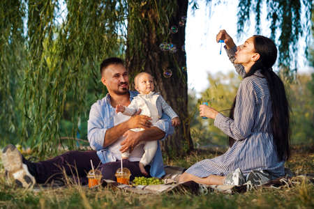 Baby having fun with bubbles at family picnic