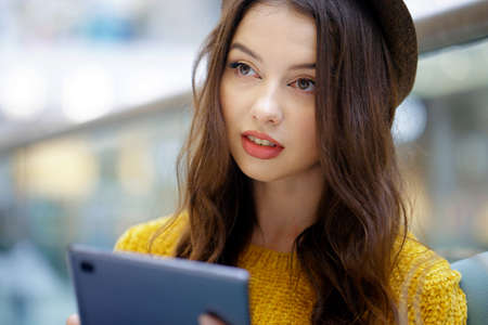 Young woman with long hair using tablet for readingの写真素材