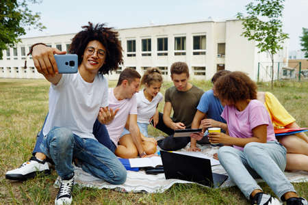 Black student recording vlog with friends on campus