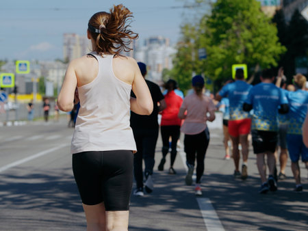 Adult tall woman running marathon in cityの写真素材