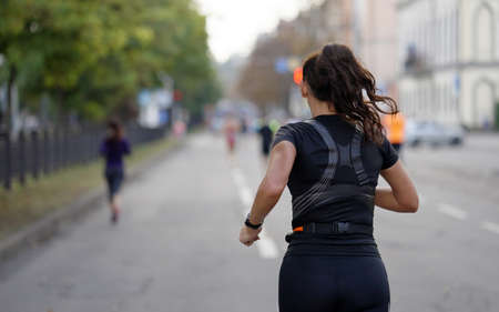 Fit brunette woman running marathon in cityの写真素材