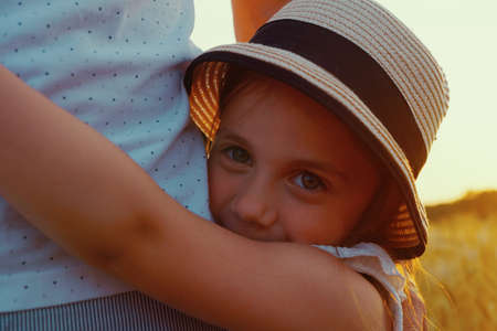 Little girl hugging her dad and looking at cameraの写真素材