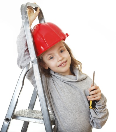 Little girl in the construction helmet with a screwdriver.の写真素材