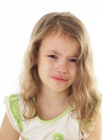 Upset little girl crying on a white background.の写真素材