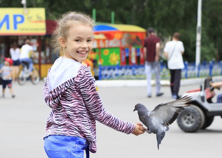 Joyful little girl with a dove on handの写真素材