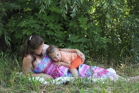 Beautiful pregnant woman tenderly deals with a little daughter.の写真素材