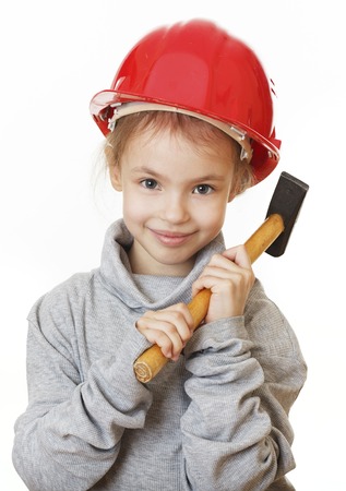 little girl in the construction helmet with a hammer.の写真素材