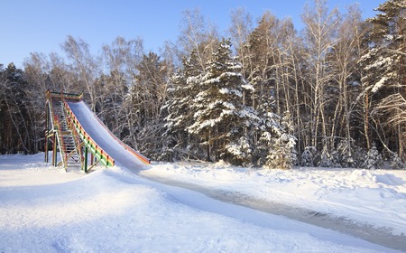 Slide covered with ice in the winter forest.の写真素材
