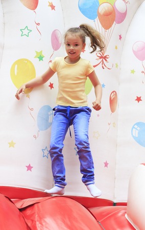 Joyful little girl playing on a trampoline.の写真素材