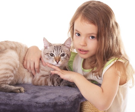 Beautiful little girl hugging her cat.の写真素材