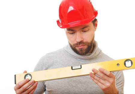 Construction worker in a red helmet with a level of hands.の写真素材