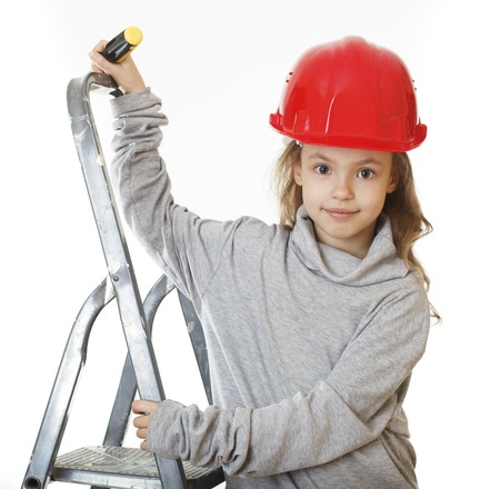 Little girl in the construction helmet with a screwdriver.の写真素材