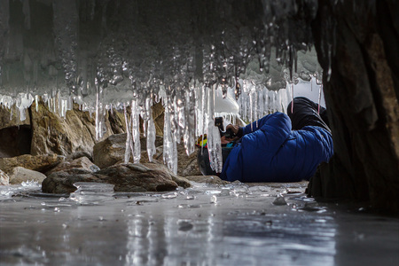 Photographer photographed in the grotto icicle. Beautiful winter landscape in the Lake Baikal.