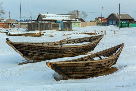 Ust-Barguzin, Russia - March 04, 2016: Wooden fishing boat on the winter snow-covered coast.のeditorial素材