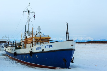 Ust-Barguzin, Russia - March 04, 2016: Ship in frozen lake covered with snow in winter eveningのeditorial素材