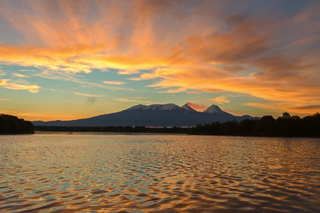 Beautiful sunrise over the volcanoes Kluchevskaya group with reflection in the river Kamchatka.の写真素材