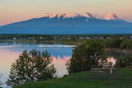 Sunset lighting Kluchevskaya group of volcanoes with reflection in the river Kamchatka.の写真素材