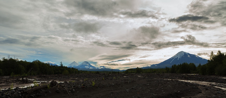 View of the volcanoes: Ostry Tolbachik, Klyuchevskaya Sopka, Bezymianny, Kamen from river Studenaya at dawn. Kamchatka Peninsula.の写真素材