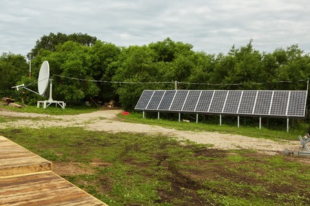 Kamchatka Peninsula, Russia - August 13, 2016: Solar panels and satellite dish on the source of river Ozernaya on Kurile lake. South Kamchatka Nature Park.のeditorial素材