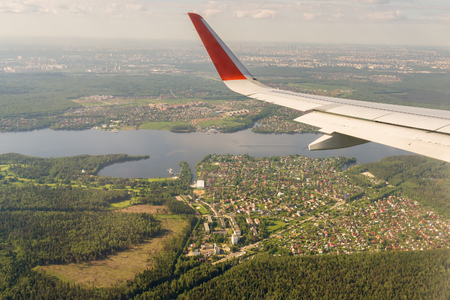 Aerial view to the wing of an airplane over Moscow Regionの写真素材