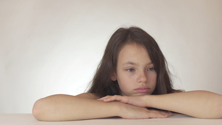 Beautiful sad teenage girl expresses resentment and sadness on a white backgroundの写真素材