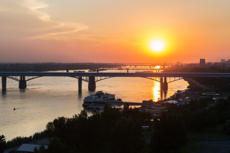 Beautiful sunset over the Octyabrsky bridge across the river Ob in Novosibirskの写真素材