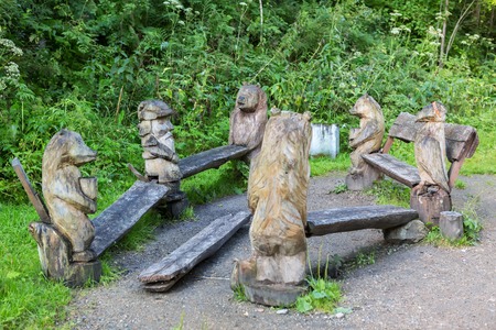 Belokurikha, Russia - July 30, 2015: Benches with wooden sculptures of animals on terrenkur health trail along the Belokurikha mountain riverのeditorial素材
