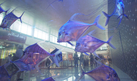 Dubai, UAE - April 09, 2018: Transparent wall aquarium with beautiful fish in the Dubai Mall, the worlds largest shopping centerのeditorial素材
